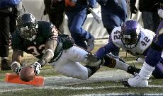 Chicago Bears running back Cedric Benson, left, dives into the end zone past Minnesota Vikings safety Darren Sharper (24) at the end of a 24-yard touchdown run during the third quarter Sunday, in Chicago. The Associated Press
