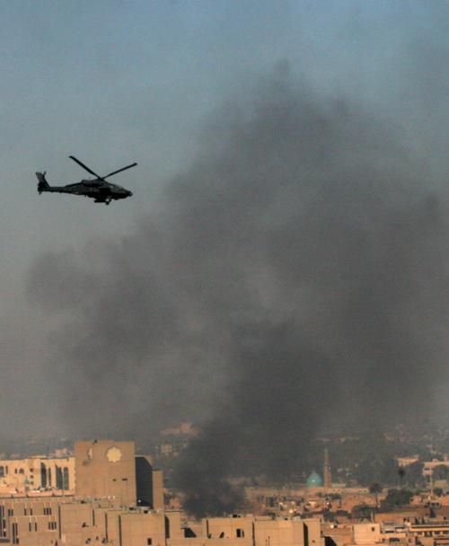 U.S. military Apache helicopter flies as smoke rises over the area where U.S. and Iraqi troops clashed with gunmen in a Sunni insurgent stronghold north of the heavily fortified Green Zone in Baghdad, Iraq, Wednesday Jan. 24, 2007. (AP Photo/Samir Mizban)
