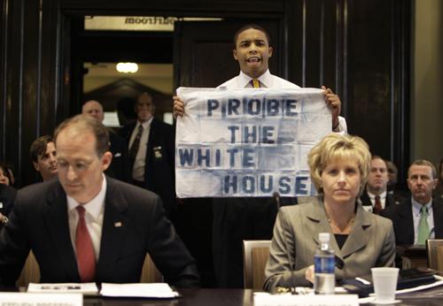 A man holds a sign and disrupts the start of a Senate Homeland Security Committee meeting on Katrina and Rita recovery as Steven Preston, left, administrator of the Small Business Administration, and HUD Assistant Secretary Pamela Patenaude look on in Ne The Associated Press
