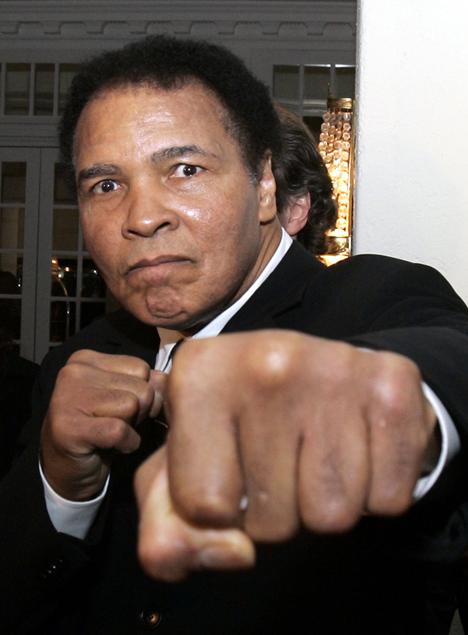 ** FILE ** Former heavyweight boxing champion Muhammad Ali gestures toward photographers in a hotel lobby in Davos, Switzerland, in this Jan. 28, 2006 file photo. (AP Photo/Michel Euler)
