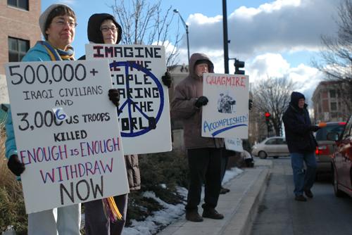 (From left) Marcia Nelson, of Champaign, Mary Miller and Belden Fields, of Urbana, hold up signs to passing motorists while Durl Kruse, (far right) of Urbana, hands out fliers at the corner of Main and Neil streets on the afternoon of Saturday, Jan. 27, 2 Beck Diefenbach

