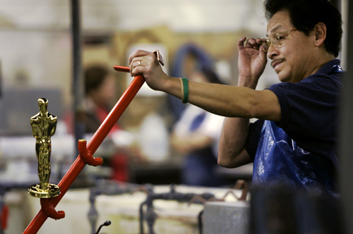 Pedro Barrera looks over an Oscar statuette after as it comes out of a 24 carat gold bath at the R.S. Owens plant in Chicago, Thursday, Jan. 18, 2007. The Oscars are presented annually at the Academy Awards ceremony in Los Angeles and the Academy uses the (AP Photo/Charles Rex Arbogast)
