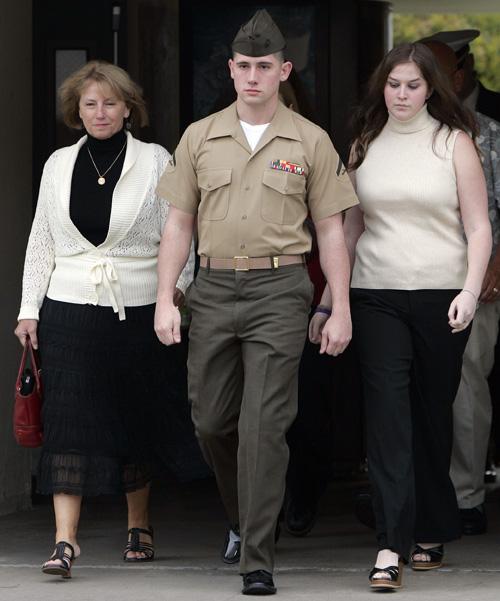 U.S. Marine Lance Cpl. Robert B. Pennington, center, walks to his court martial proceedings alongside his mother, Deanna Pennington, left. The Associated Press
