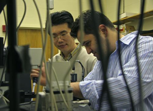 Physics professor Taekjip Ha, left, and post doctoral student Burak Okumus demonstrate lab procedures while discussing their research that was recently published in Loomis Lab, Friday. Using ultra-sensitive single molecule microscopy they were able to wat ME Online
