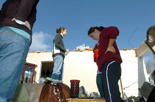 Melissa Landry, center, stands on her bed after a tornado ripped off the roof of her home, which was located in the path of a suspected tornado in the Breaux Bridge area of south-central Louisiana early Tuesday. The Associated Press
