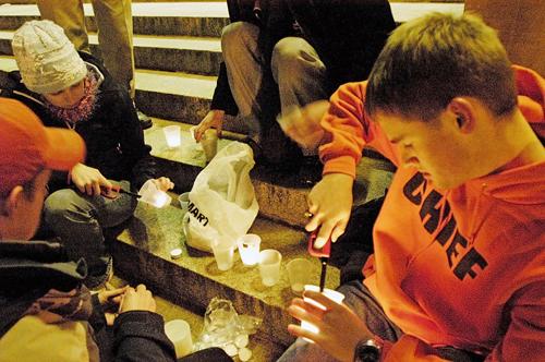 David Shier, freshman in ACES, right, lights candles for participants at the candlelight vigil held by the Students for Chief Illiniwek. The event was held Monday night in front of Foellinger Auditorium. ME Online
