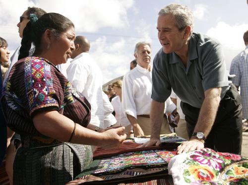 U.S. President George W. Bush, right, talks with a local woman vendor during his visit to the town plaza of Santa Cruz Balanya, Guatemala, Monday, March 12, 2007. Guatemala President Oscar Berger is at center. The Associated Press
