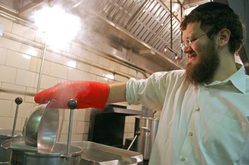 Rabbi Dovid Tiechtel koshers a cooking pan in the Lincoln Avenue Residence hall test kitchen, Feb. 7. Allen and Gregory residence halls will now be serving kosher food every other Wednesday for dinner. Beck Diefenbach
