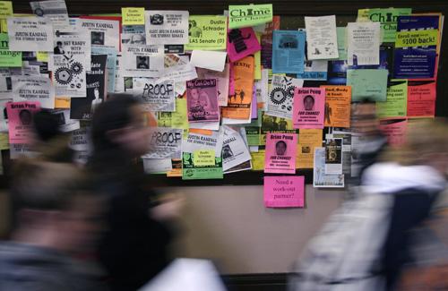 Student shuffle past a bulletin board covered with fliers for the upcoming student elections in Lincoln Hall, Monday. ME Online
