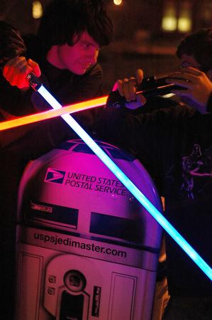 (Left) Wayne Neumaier, senior in Engineering, and Chris Smith, junior in Economics duel for the freedom of the galaxy above a painted United States Postal Service mailbox painted as the Star Wars character R2-D2 on Tuesday in this portrait illustration. & Beck Diefenbach
