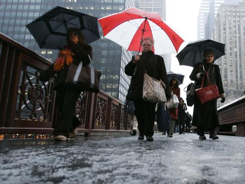 Pedestrians make their way across an icy bridge in a light snowfall Wednesday, in downtown Chicago. Mike Derer, AP
