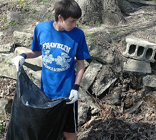 Two Franklin Middle School students search for trash in Boneyard Creek on Saturday. The clean-up lasted from 9 a.m. to noon and was part of the Boneyard Arts Festival. Beck Diefenbach
