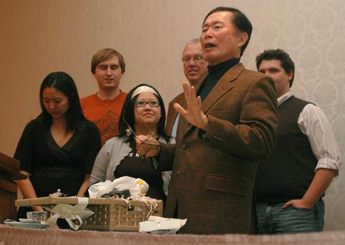 George Takei, actor from popular television shows Star Trek and Heroes, opens a gift basket from sponsoring organizations: Asian American Association, Asian American Cultural Center, Asian American Studies, Colors of Pride, Office of LGBT Resources, a ME Online
