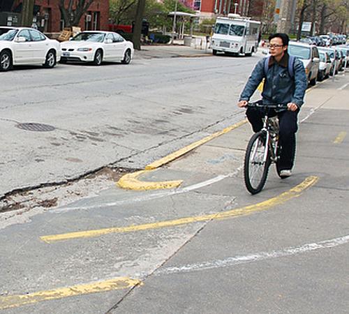 Graduate student Yi Wang rides his bike along the designated bike path down Mathews Avenue on April 13. Urbana City Council is working on the Bike Master Plan to make bike routes safer and easier to use. Beck Diefenbach
