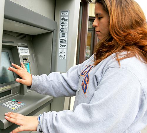 Melissa Rodriguez, freshman in ACES, checks her balance at a Chase ATM located on Daniel Street on Thursday. I am worried about catching up with my bills after I graduate, Rodriguez said. Rodriguez, like many other students, uses financial ai Beck Diefenbach
