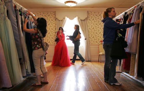 Roxana Davison, center, helps her daughter Shannon Davison, 16, pick out a dress at the Perfect Prom Project boutique on Sunday afternoon in the Illini Union. Volunteer Lihui Chen, 23, left, and Oakland High School student Jessie Baker, 16, right, also b Beck Diefenbach
