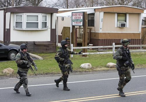 Law enforcement personnel search a mobile home park in Branchburg, N.J., on Thursday. The mobile home park is located about three miles south of the PNC bank where an FBI agent was killed in a bank robbery shootout. Tim Larsen, AP
