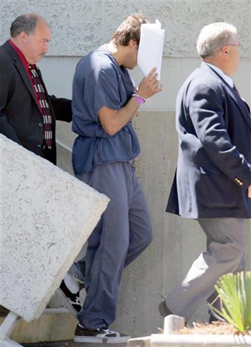 Joe Francis, center, uses papers to block his face as he leaves the federal courthouse in Panama City, Fla., on Thursday, April 12, 2007. Francis was charged Wednesday, April 25, 2007, in Los Angeles with misdemeanor sexual battery for allegedly groping a The Associated Press
