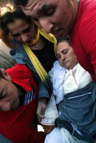 Family members and emergency workers carry an injured woman into an ambulance after a second explosion occurred in the working-class Hay Farah neighborhood of Casablanca, Morocco on Tuesday. Two suspected terrorists blew themselves up as police were closi Abdeljalil Bounhar, AP
