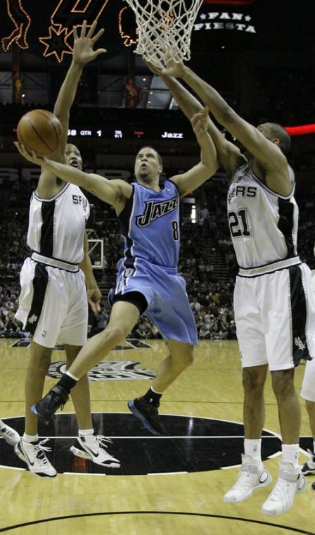 Utah Jazz guard Deron Williams (8) drives to the basket between San Antonio Spurs forward Robert Horry, left, and Spurs forward Tim Duncan (21) in the second quarter of their Western Conference playoff basketball game, Sunday in San Antonio The Associated Press
