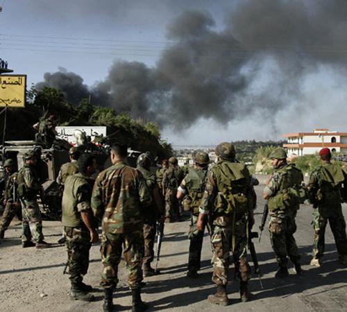 Lebanese army soldiers look at smoke bellowing into the sky as a result of heavy shelling by the Lebanese army, at the Palestinian refugee camp of Nahr el-Bared, during a clashes with fighters from the Fatah Islam militant group, in the northen city of Tr The Associated Press
