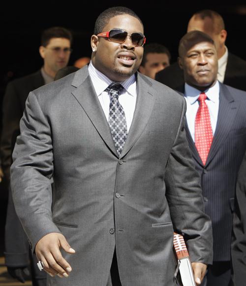 Chicago Bears defensive lineman Tank Johnson, left, enters Cook County Court accompanied by Bears head coach Lovie Smith, right, in Skokie, Ill., in this March, 15, 2007, file photo. Johnson is scheduled to meet with NFL Commissioner Roger Goodell Wednesa The Associated Press
