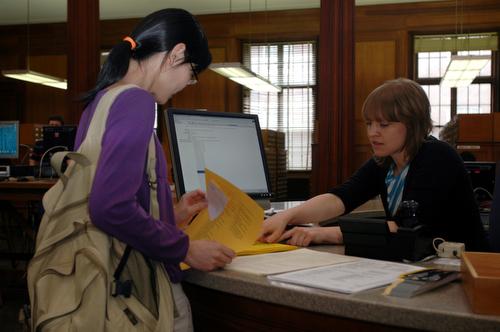 Yu Dong, left, graduate student, gets help from Lena Singer, graduate student in Library and Information Sciences, at the information desk in the Main Library on Wednesday. Beck Diefenbach
