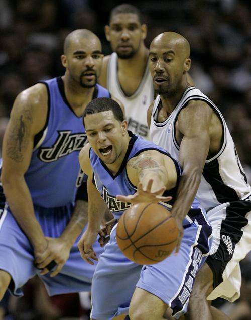 Utah Jazz guard Deron Williams, center, reaches for a loose ball as San Antonio Spurs forward Bruce Bowen, right, defends during the fourth quarter of their Western Conference Finals NBA basketball game in San Antonio, Sunday. San Antonio won 108-100. Ja The Associated Press
