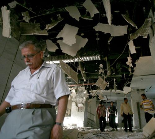 People stand in a bombed out lobby of the Mansour Hotel in Baghdad on Monday. A suicide bomber apparently targeting a meeting of U.S.-allied Sunni sheiks penetrated security and blew himself up in the lobby, killing four of the tribal leaders. Hadi Mizban, The Associated Press
