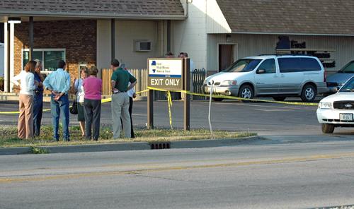 A group of employees and victims of a hostage situation in Arcola, Ill., stand outside of the bank where the nine-hour ordeal occured. Police were able to resolve the situation without any of the five hostages being hurt, although a police officer was sho Steve Contorno
