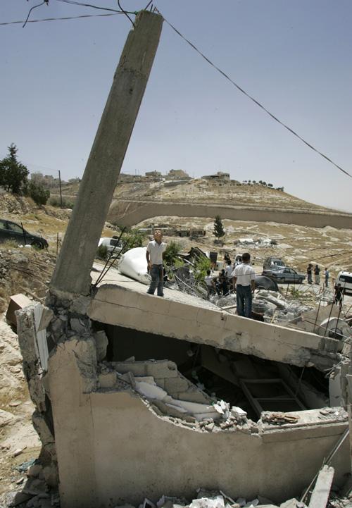 A Palestinian youth is seen on top of a house demolished by Israeli bulldozers at the East Jerusalem neighborhood of Jabel Mukaber Monday, June 11, 2007. Israel often demolishes houses in east Jerusalem they say were built without proper permits. The Associated Press
