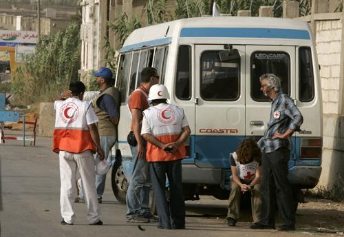 Red Crescent and Red Cross workers react as they stand outside the Nahr el-Bared refugee camp near Tripoli, in northern Lebanon, after hearing two Red Cross workers had been killed, Monday June 11, 2007. Two local Red Cross workers were killed and a third The Associated Press
