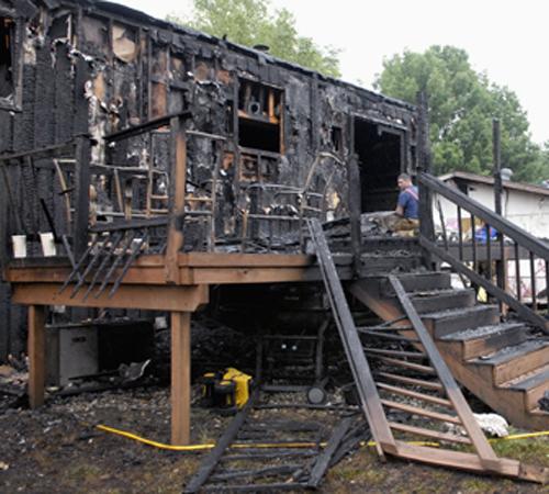 Firefighters and police investigate a house in Champaign, Ill., early Friday, June 22, 2007, where an overnight fire resulted in the deaths of a 30-year-old man and his 5-year-old stepson. Two other family members were injured in the blaze. Investigators Darrell Hoemann, The Associated Press
