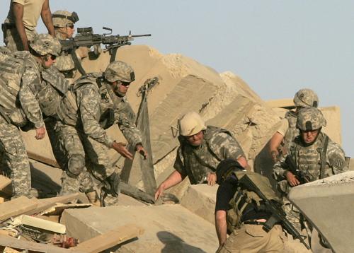 U.S. troops and private security guards, in black, work to remove concrete rubble from atop wounded soldiers, at a bridge destroyed by an apparent suicide vehicle bomber on Sunday, June 10, 2007, outside Mahmoudiya, about 30 kilometers (20 miles) south o The Associated Press
