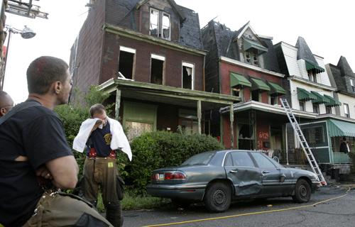 Pittsburgh firefighters take a break after fighting a fatal fire on Winslow Ave. in the Larimar section of Pittsburgh early Tuesday June 12, 2007. Fire swept through the three-story home, 2nd from left, early Tuesday, killing five children, ages 2 to 7, a The Associated Press
