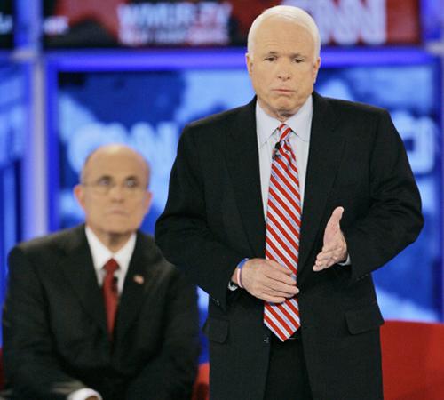 Republican presidential hopeful Sen. John McCain, R-Ariz., standing, answers a question, while former New York City Mayor Rudy Giuliani, left, listens during the Republican presidential primary debate hosted by Saint Anselm College in Manchester, N.H., Tu The Associated Press
