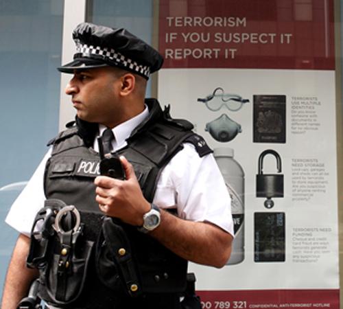 A police officer stands guard outside Scotland Yard. British officials announced the arrest of a fifth suspect on Sunday as part of their sweeps across the country to eliminate an al-Qaida-linked network. Simon Dawson, The Associated Press
