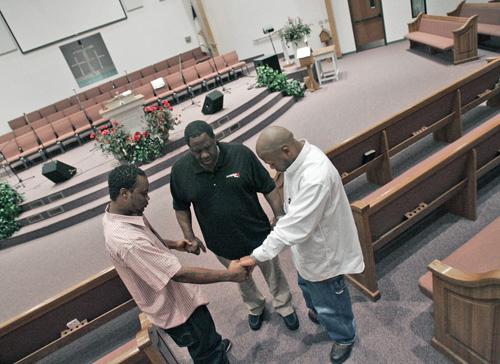 The Rev. Jack Crane, center, prays with former gang members at their church in Fort Worth, Texas on June 27. Crane is working with them to reach out to current gang members to try to stop violence. LM Otero, The Associated Press
