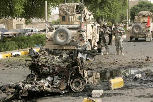 U.S. Army soldiers examine the wreckage from a car bomb attack that injured a woman in a neighborhood in western Baghdad. Attacks in Baghdad killed 13 people on Monday. Khalid Mohammed, The Associated Press
