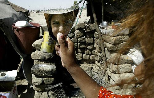 A young Iraqi girl holds up a piece of a broken mirror in the Shiite holy city of Najaf, 160 kilometers (100 miles) south of Baghdad, Iraq, on Thursday. Al-Qaida forces attacked two villages near Baqouba. THE ASSOCIATED PRESS, ALAA AL-MARJANI
