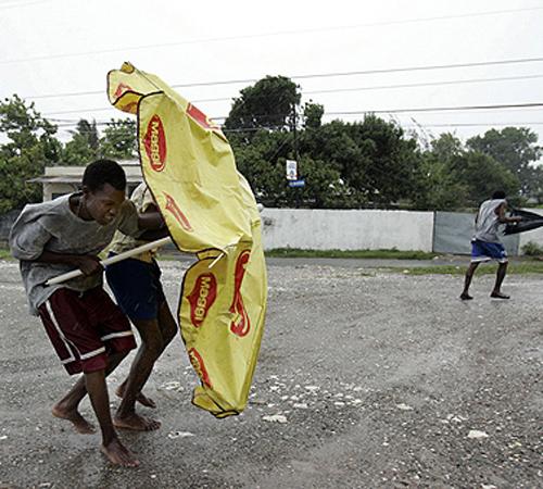 Young boys use an umbrella to resist the wind while walking at a street of Kingston during the pass of Hurricane Dean over Jamaica on Sunday. Hurricane Dean pummeled the country with strong winds and torrential rains THE ASSOCIATED PRESS, ADRES LEIGHTON
