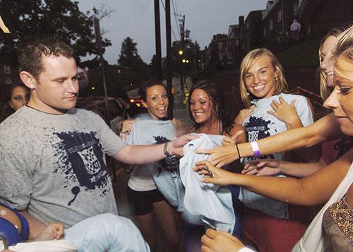 West Virginia senior Adam Gibson passes out free T-shirts from PlayboyU.com to advertise the social networking site in Morgantown, W.Va., on Monday. THE ASSOCIATED PRESS, DALE SPARKS
