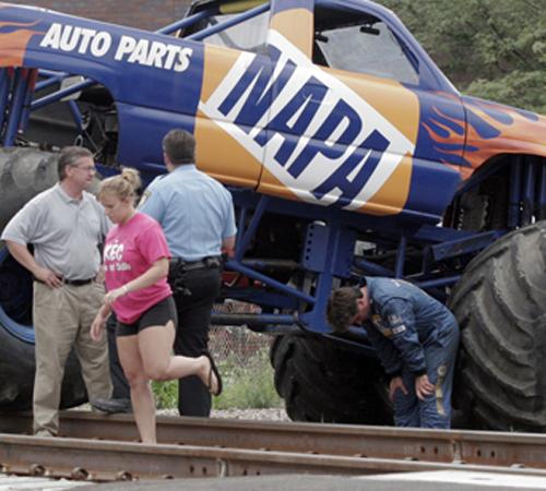 The driver of the monster truck, who declined to be identified, which crashed through a crowd of onlookers during a car crushing demonstration, leans against the wheel of his truck as emergency personnel talk to officials on Thursday, Aug. 9, 2007, in DeK Eric Sumberg, the Daily Chronicle from The Associated Press
