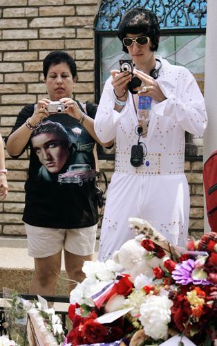 Stephan Schuttes, right, of London, photographs the grave of Elvis Presley along with Lorraine Marrero, left, of New York, on the grounds of Graceland in Memphis, Tenn., on the 30th anniversary of his death Thursday, Aug. 16, 2007. Mark Humphrey, The Associated Press
