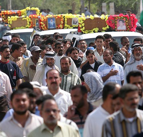Iraqi people march during a burial ceremony held for 30 bodies that were found in a mass grave in southwestern Basra on Thursday. THE ASSOCIATED PRESS, NABIL AL-JURANI
