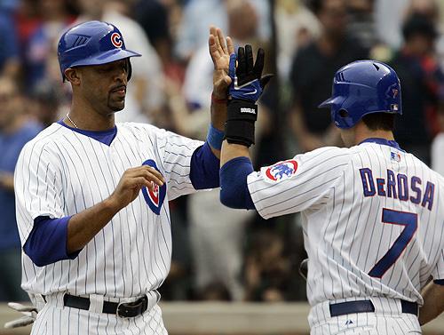 Derrek Lee, left, high fives with Mark DeRosa after Lee scored on an RBI single by Cliff Floyd during the first inning against the St. Louis Cardinals on Monday in Chicago. The Cubs won 12-3. THE ASSOCIATED PRESS, M. SPENCER GREEN
