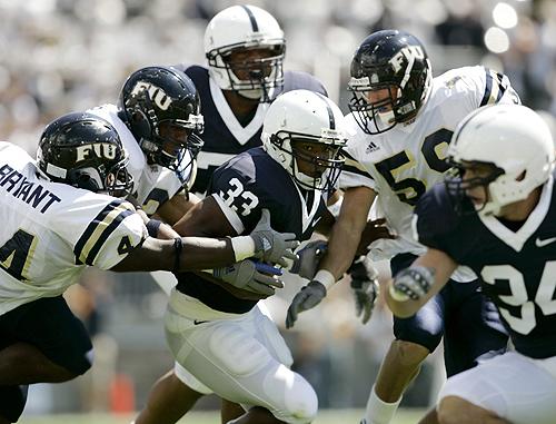 Penn State tailback Austin Scott, (33) center, rushes the ball up the field while being pursued by Florida International defenders from left, Scott Bryant, Ricky Booker, and Cody Pellicer, right, during the first half of their football game on Saturday i THE ASSOCIATED PRESS, CAROLYN KASTER
