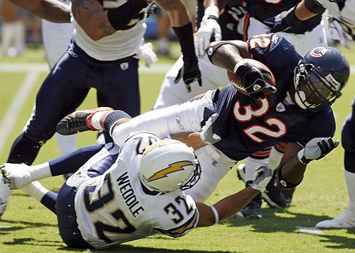 Bears tailback Cedric Benson is brought down by Chargers safety Eric Weddle after a short gain in San Diego on Sunday. The Bears will start Danieal Manning and Darwin Walker at safety and nose tackle, respectively, on Sunday. THE ASSOCIATED PRESS, JACK SMITH
