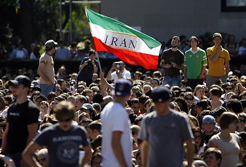 A student waves an Iranian flag while waiting to listen to the simulcast of a speech by Iranian President Mahmoud Ahmadinejad on the campus of Columbia University on Monday in New York. Students rallied both for and against the right of Ahmadinejad to ful THE ASSOCIATED PRESS, JASON DECROW
