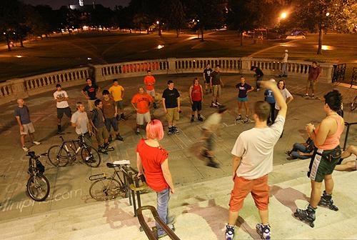A member of the Inline Insomniacs signals the direction that the skaters will start their midnight skate in front of Foellinger Auditorium on Wednesday. The group meets once a month at midnight to go for a skate around the community. Erica Magda
